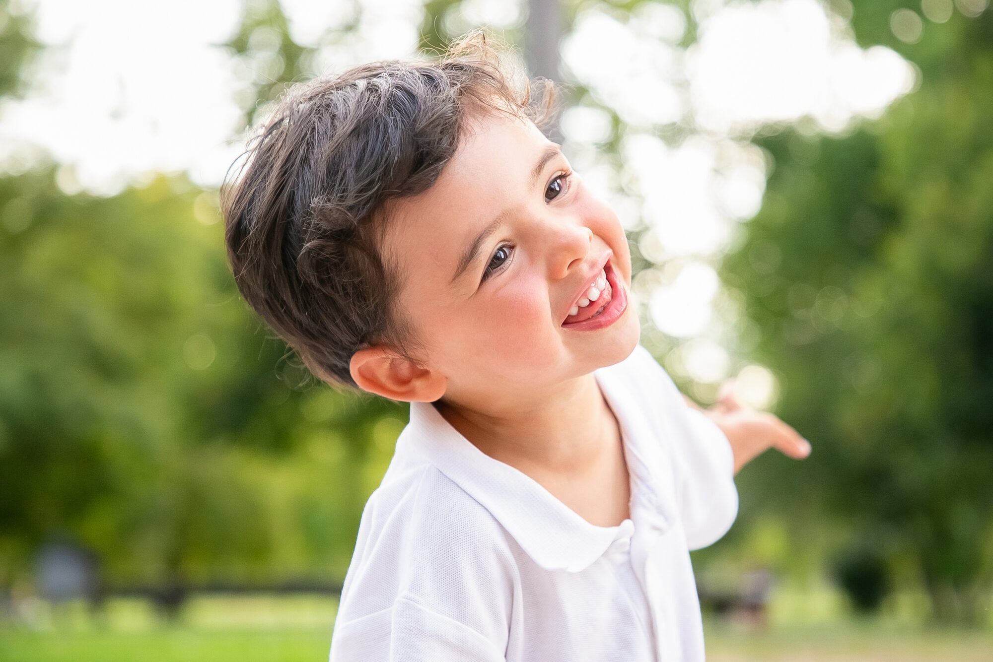 A young boy laughing outdoors